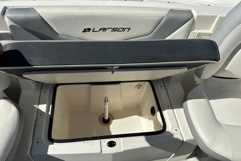 Slide: The Image of 2013 Larson LX 180S OB boat storage compartment with open lid, showcasing interior space. - 9