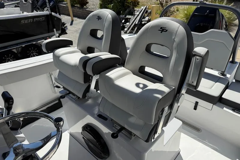Slide: The Image of 2026 Sea Pro 245FLX Sandbar boat interior with dual captain's chairs and steering wheel. - 10