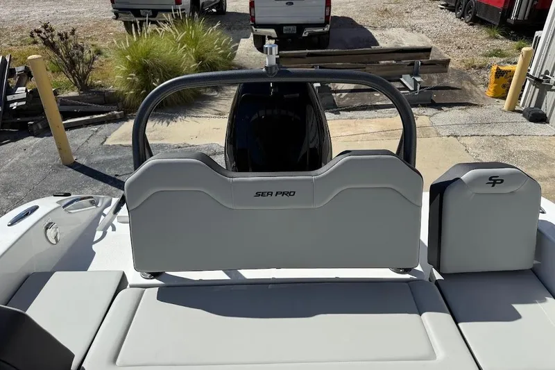 Slide: The Image of 2026 Sea Pro 245FLX Sandbar boat interior with seating and backrest, parked outdoors. - 14