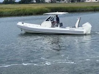 Slide: The Image of 2026 Brig Eagle 8 boat cruising on a calm river with lush green banks. - 10