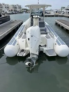Slide: The Image of 2026 Brig Eagle 8 boat docked at marina, rear view with outboard motor. - 37
