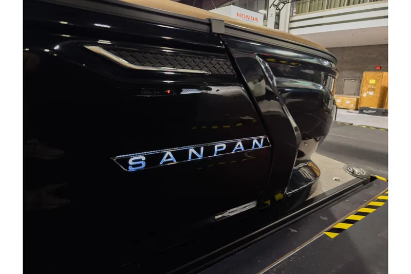 Slide: The Image of 2026 Godfrey SanPan 25' Split Bench Co-Captain boat, sleek black exterior, illuminated logo. - 3