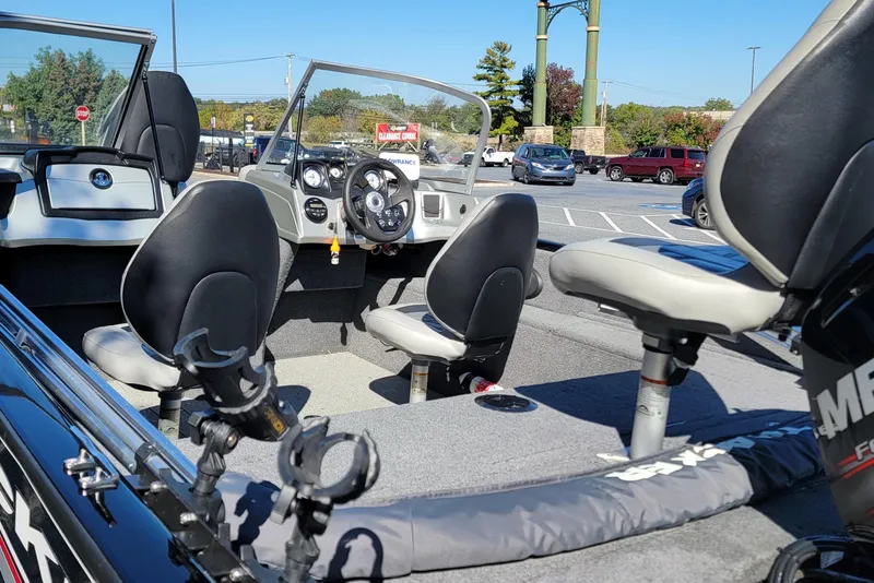 Slide: The Image of 2019 Tracker Pro Guide V-175 Combo boat interior with seating and steering wheel in a parking lot. - 7