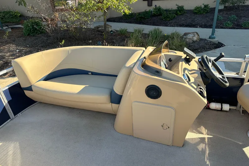 Slide: The Image of 2015 Harris FloteBote Cypress Cay Cambio 180 boat interior with beige seating and steering console. - 5