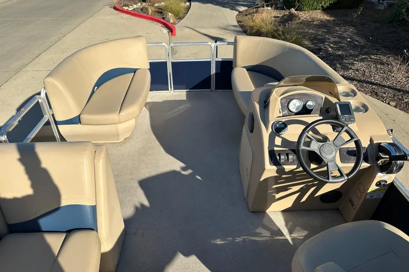 Slide: The Image of 2015 Harris FloteBote Cypress Cay Cambio 180 pontoon boat interior with beige seating and steering console. - 8