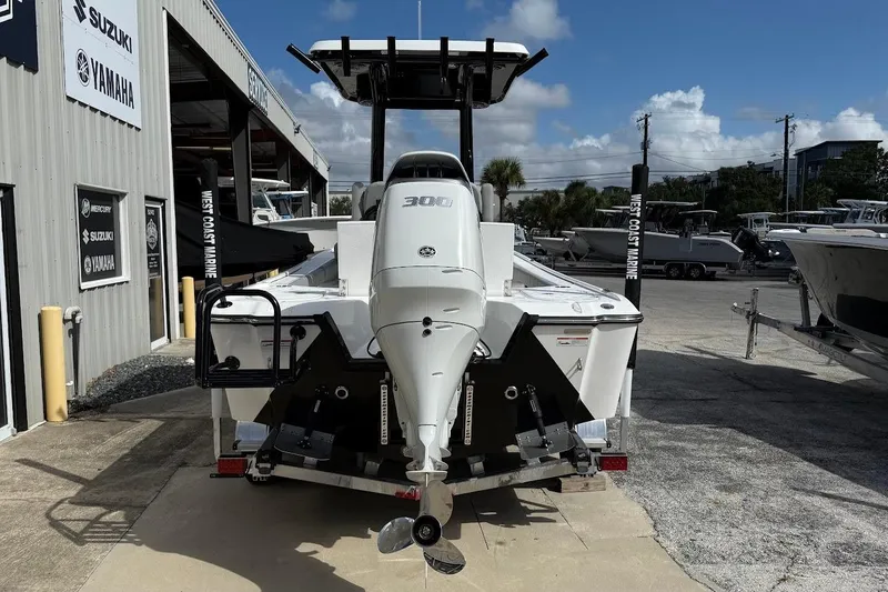 Slide: The Image of 2026 Blazer Bay 2440 boat with powerful outboard motor at a marine dealership. - 8