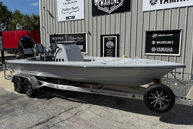 The Image of 2026 Blazer 675 Ultimate Bay boat on trailer outside marine dealership. - 1