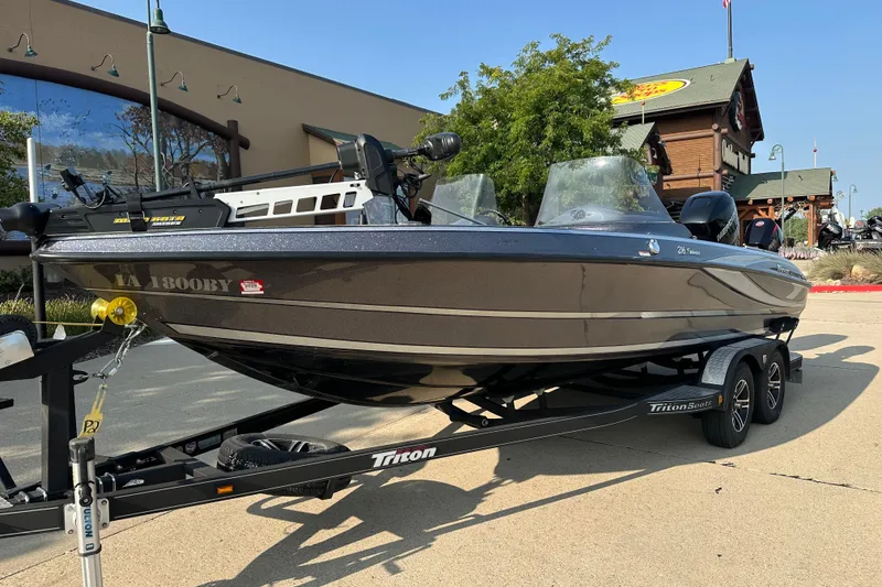 Slide: The Image of 2018 Triton 216 Fishunter boat on trailer, parked outdoors near a building. - 1