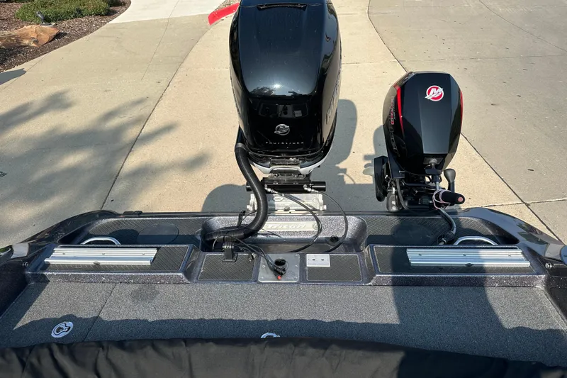 Slide: The Image of 2018 Triton 216 Fishunter boat with dual outboard motors on a concrete driveway. - 12