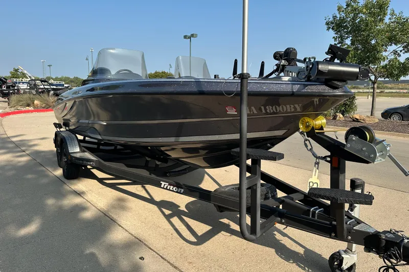 Slide: The Image of 2018 Triton 216 Fishunter boat on trailer in outdoor setting. - 2