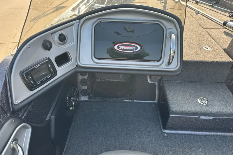 Slide: The Image of 2018 Triton 216 Fishunter boat dashboard with control panel and storage compartments. - 8