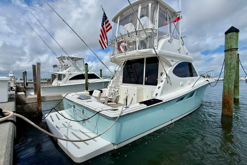 Slide: The Image of 2006 Tiara Yachts 3900 Convertible docked at marina, featuring sleek design and American flag. - 2
