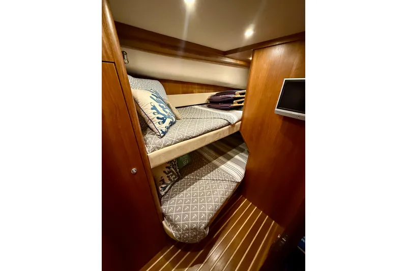 Slide: The Image of 2006 Tiara Yachts 3900 Convertible cabin with cozy bunk beds and wooden interior. - 25