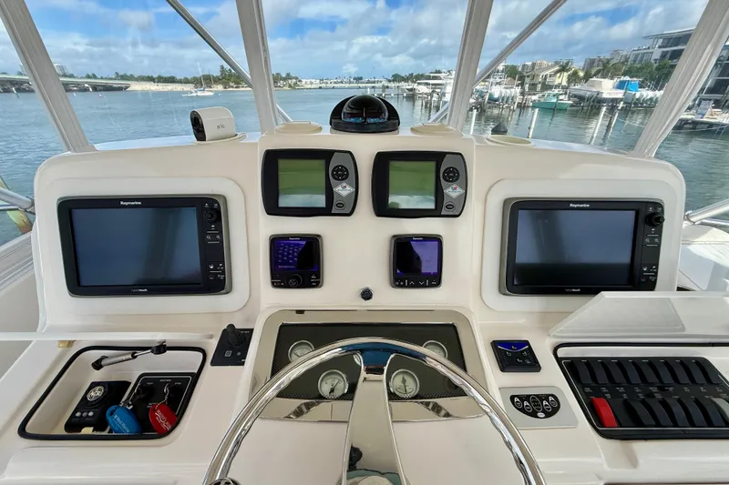 Slide: The Image of Helm of 2006 Tiara Yachts 3900 Convertible with navigation screens and controls, overlooking marina. - 34