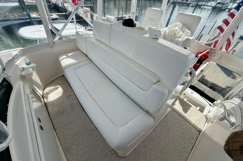 Slide: The Image of 2006 Tiara Yachts 3900 Convertible interior with white seating and marina view. - 36