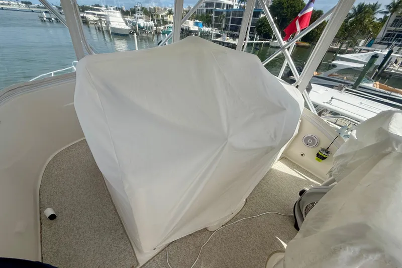 Slide: The Image of 2006 Tiara Yachts 3900 Convertible boat interior with covered equipment and marina view. - 37