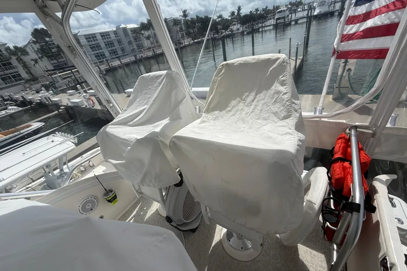 Slide: The Image of 2006 Tiara Yachts 3900 Convertible helm with covered seats and marina view. - 38