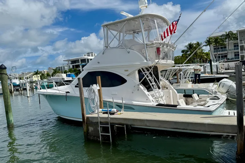 Slide: The Image of 2006 Tiara Yachts 3900 Convertible docked at marina, featuring sleek design and American flag. - 4