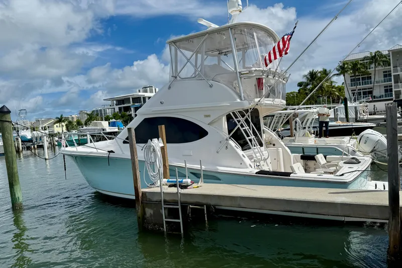 Slide: The Image of 2006 Tiara Yachts 3900 Convertible docked at marina, featuring sleek design and American flag. - 52