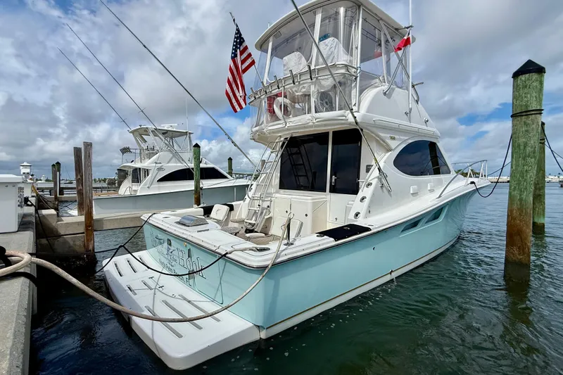 Slide: The Image of 2006 Tiara Yachts 3900 Convertible docked at marina, featuring sleek design and American flag. - 54