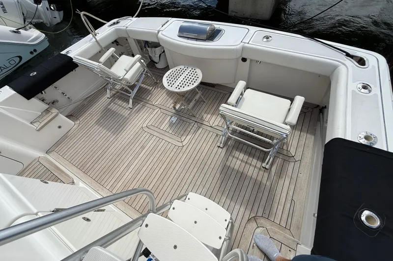Slide: The Image of 2006 Tiara Yachts 3900 Convertible deck with seating and table, featuring teak flooring. - 9