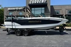 Slide: The Image of 2025 MasterCraft X24 boat on trailer outside dealership. - 22