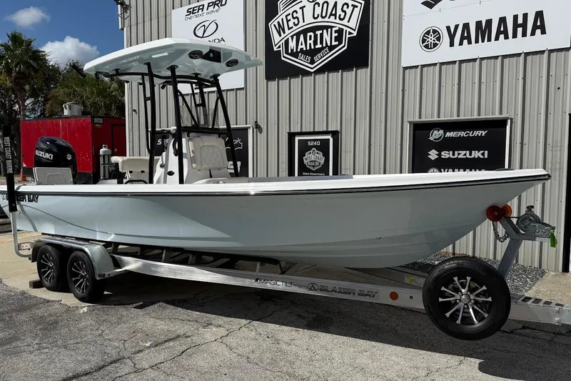 The Image of 2026 Blazer PureBay 2400 boat on trailer at West Coast Marine dealership. - 1