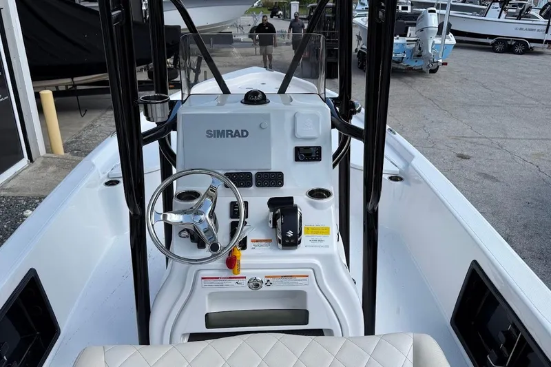 Slide: The Image of 2026 Blazer PureBay 2400 boat cockpit with steering wheel and Simrad electronics. - 13