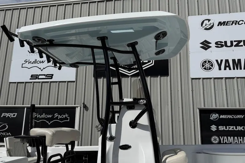 Slide: The Image of 2026 Blazer PureBay 2400 boat with T-top, displayed at a marine dealership. - 4