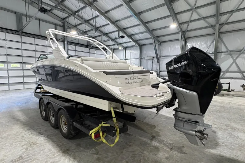 Slide: The Image of 2022 Sea Ray SDX 270 Outboard boat on trailer in parking lot, surrounded by trees. - 3