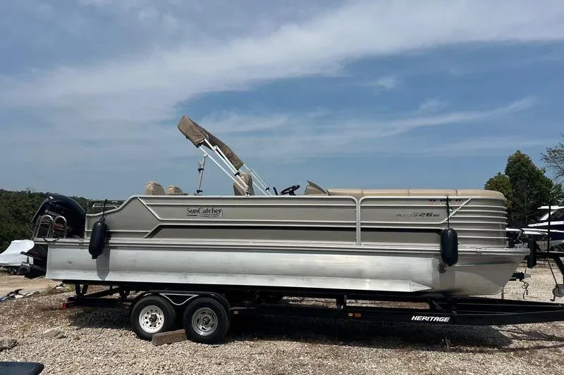 Slide: The Image of 2018 SunChaser 326 pontoon boat on trailer, parked outdoors under clear sky. - 0