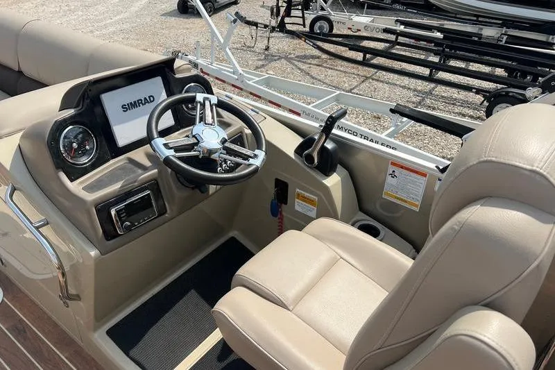 Slide: The Image of 2018 SunChaser 326 boat cockpit with steering wheel, Simrad display, and beige seating. - 11