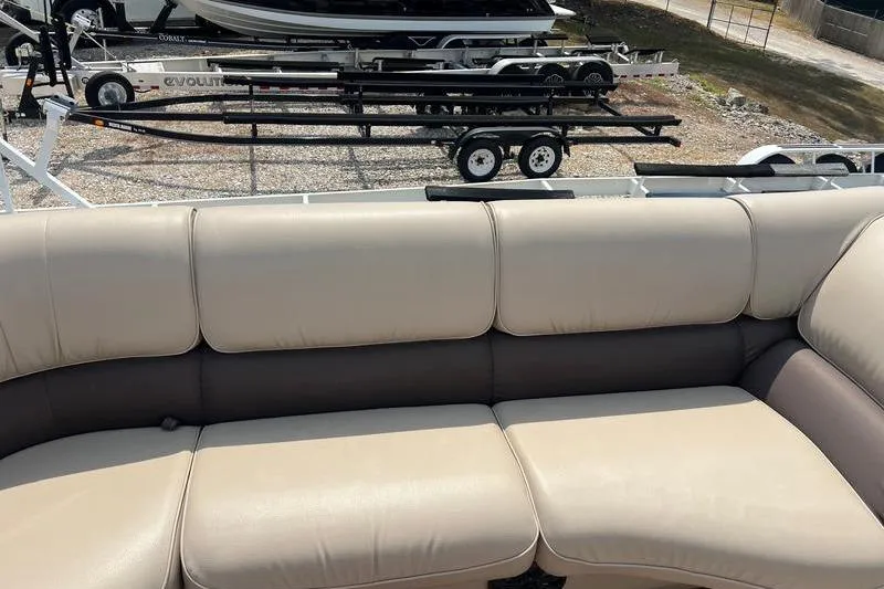 Slide: The Image of 2018 SunChaser 326 boat interior with beige seating and trailer in background. - 4