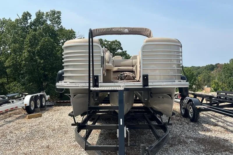 Slide: The Image of 2018 SunChaser 326 pontoon boat on trailer, surrounded by trees. - 5
