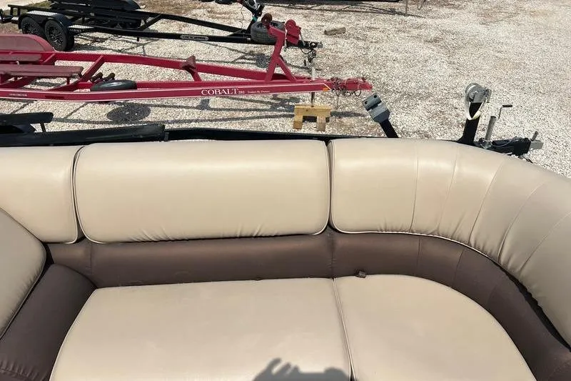 Slide: The Image of Beige and brown seating on a 2018 SunChaser 326 boat, with trailers in the background. - 8