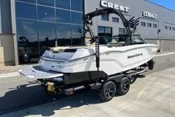 Slide: The Image of 2025 MasterCraft NXT22 boat on trailer outside dealership building. - 12