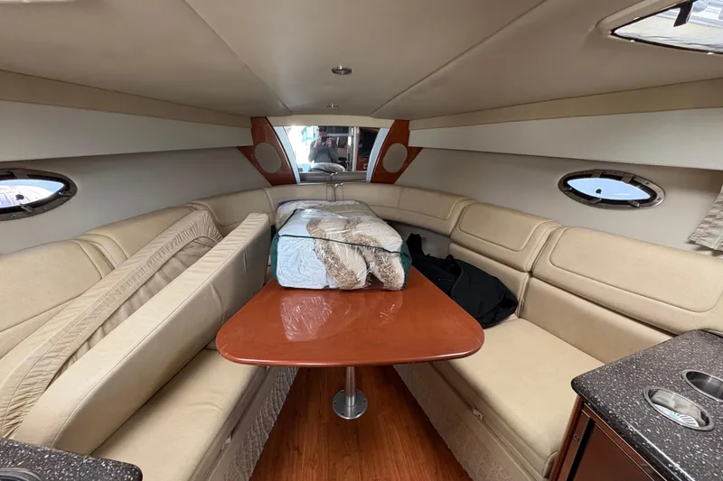 Slide: The Image of Interior of 2008 Formula 350 Sun Sport boat with beige seating and wooden table. - 16