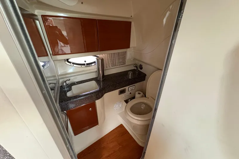 Slide: The Image of 2008 Formula 350 Sun Sport boat bathroom with sink, toilet, and wooden cabinetry. - 21