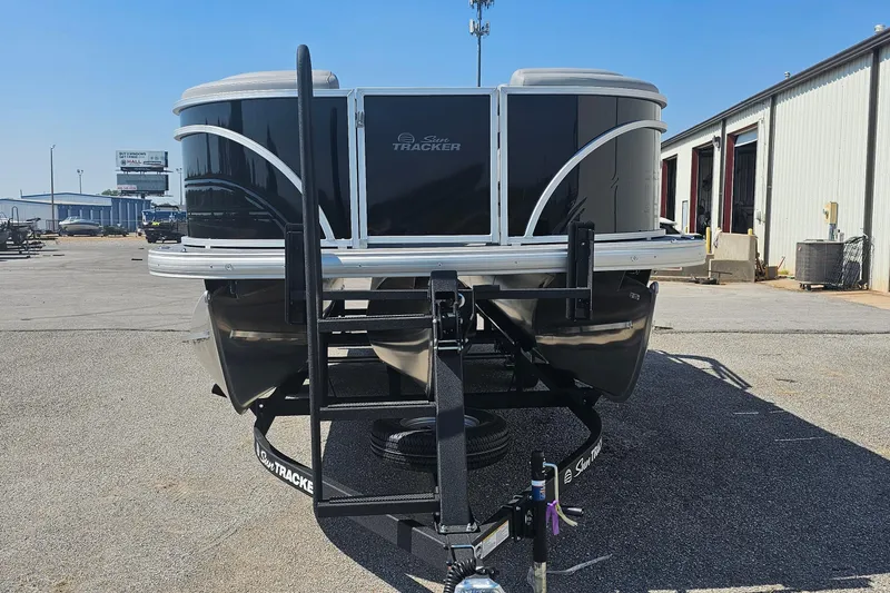 Slide: The Image of 2026 Sun Tracker Party Barge 22 RF XP3 pontoon boat on trailer in parking lot. - 2
