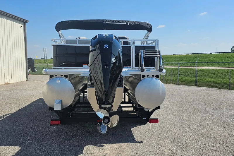 Slide: The Image of 2026 Sun Tracker Party Barge 22 RF XP3 pontoon boat with outboard motor, parked outdoors. - 3