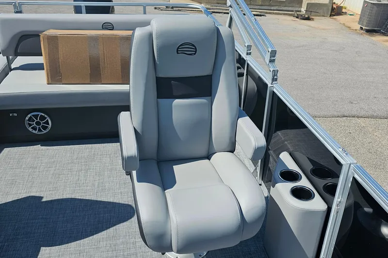 Slide: The Image of 2026 Sun Tracker Party Barge 22 RF XP3 interior with gray captain's chair and cup holders. - 8
