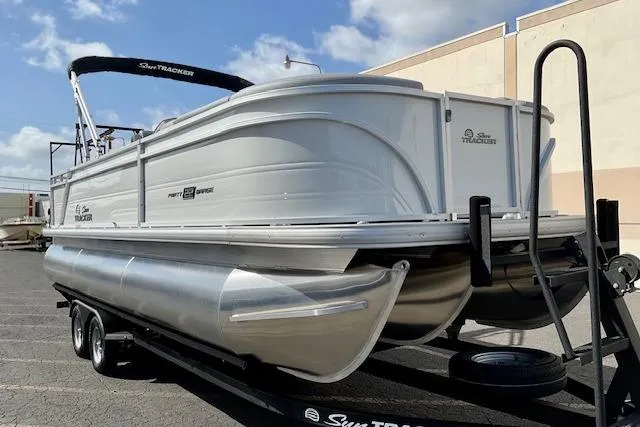 The Image of 2026 Sun Tracker Party Barge 22 RF XP3 pontoon boat on trailer, parked outdoors. - 0