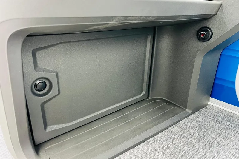 Slide: The Image of 2026 Sun Tracker Party Barge 22 RF DLX storage compartment with sleek design and button feature. - 34