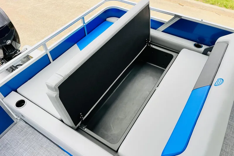 Slide: The Image of 2026 Sun Tracker Party Barge 22 RF DLX with open storage compartment and blue-gray seating. - 48