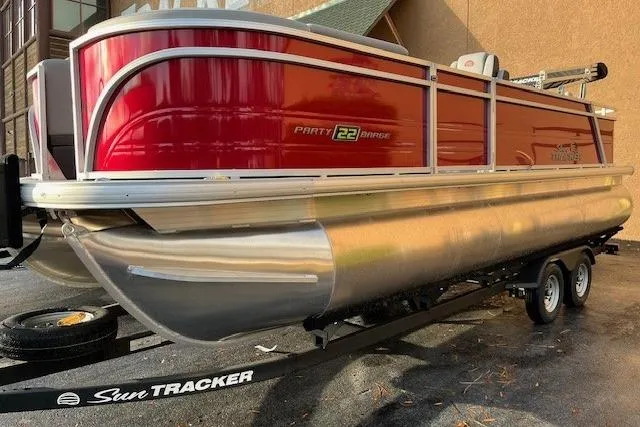 The Image of 2026 Sun Tracker Party Barge 22 RF XP3 pontoon boat on trailer, red exterior. - 0