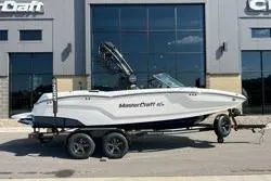 The Image of 2025 MasterCraft NXT20 boat on trailer outside dealership. - 1