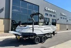 Slide: The Image of 2025 MasterCraft NXT20 boat on trailer outside dealership building. - 3