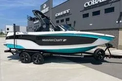Slide: The Image of 2025 MasterCraft XT22 boat on trailer, parked outside dealership. - 11