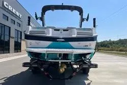 Slide: The Image of 2025 MasterCraft XT22 boat, rear view, parked outdoors on a sunny day. - 12