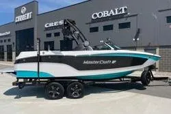Slide: The Image of 2025 MasterCraft XT22 boat on trailer, parked outside dealership. - 16